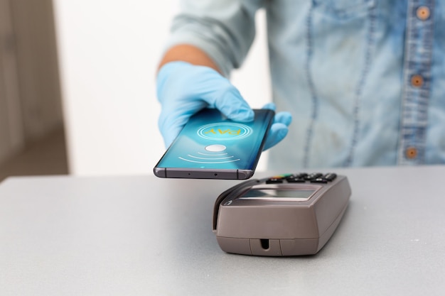 Contactless mobile payment. Payment terminal and smartphone in hands