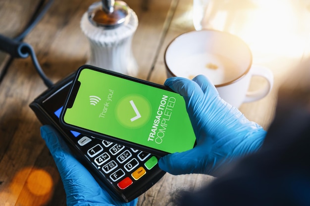 Contactless payment on a mobile phone Close up of a woman hand paying contactless with a smartphone screen application Hand holding smart device to pay Mockup cellphone screen