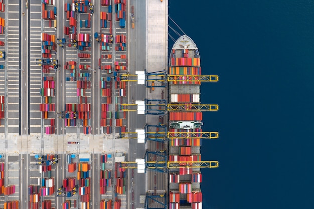 Container cargo ship loading at port, Freight transportation import export and business logistic by container ship, Aerial view.