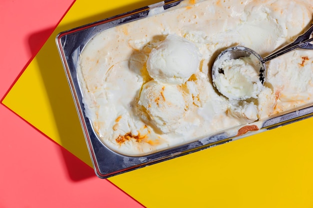 A container of ice cream with a scoop of ice cream on it.