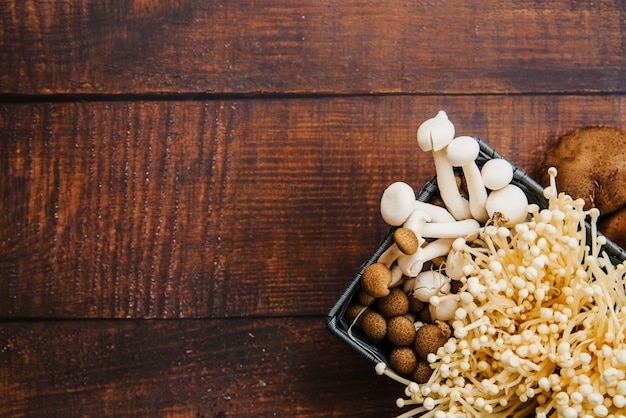 Container of mushrooms on wooden table