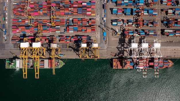 Container ship loading and unloading in deep sea port, aerial\
top view business service and commercial trading logistic import\
and export freight transportation international open sea\
woldwide