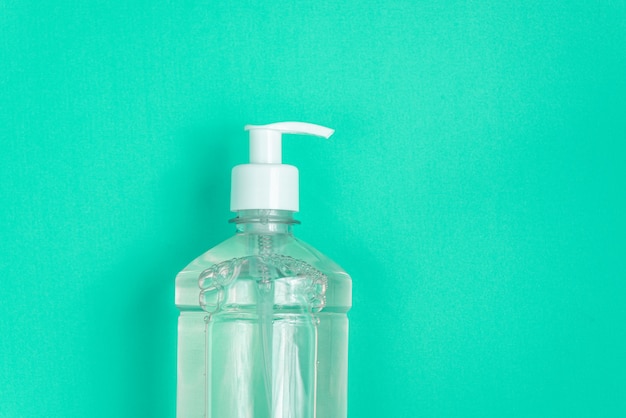 Container with alcohol gel on the light blue wall