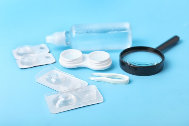 Containers for contact lenses, solution, magnifier and tweezers