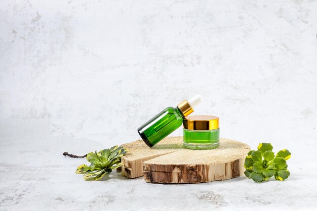 Containers for cosmetics on the podium made of cut wood and green flower leaves