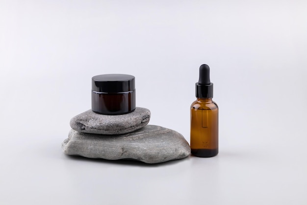 Containers for cosmetics on the podium made of stone on a gray background