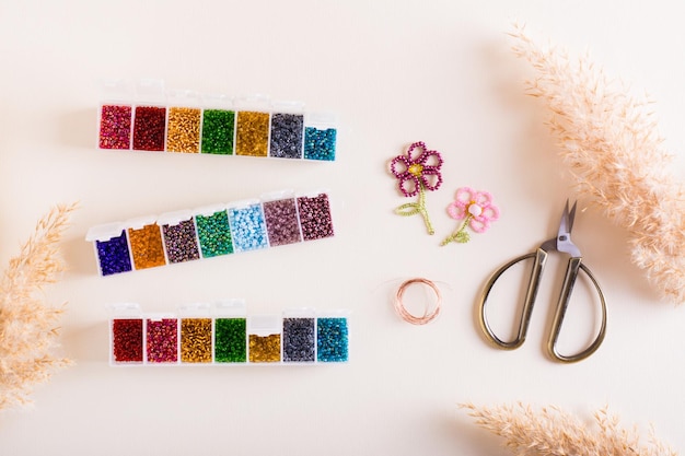 Containers with colored beads and accessories for making beadwork Needlework and handmade Top view