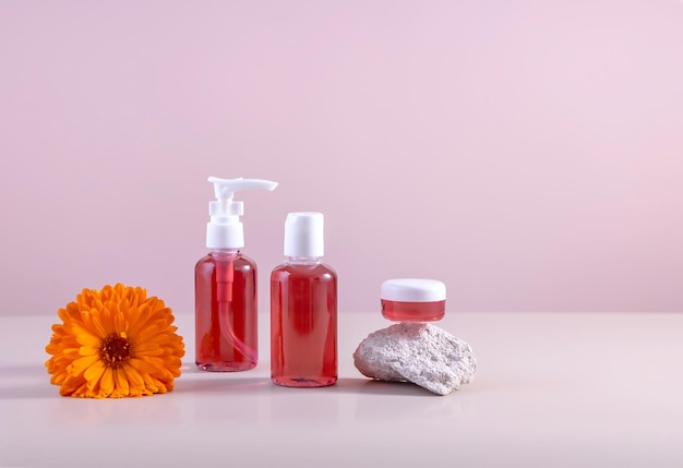 Containers with cosmetics a calendula flower and a stone