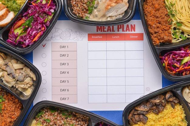 Containers with healthy food and meal plan on color