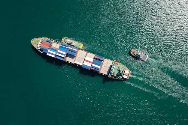 Containerschip en sleepboot slepen drijvend in groene zee bedrijfsleven en industrie Transportvrachtlogistieke diensten van internationaal per containerschip in oceaan