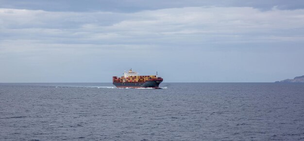 Containervrachtschip vol geladen vaart op open zee achtergrond Import export watertransport