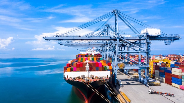 Containervrachtschip vrachtverzending lossen op originele bestemmingshaven met kadekraan, Zakelijke commerciële wereldwijde overzeese logistieke import export containerbox per containerschip.