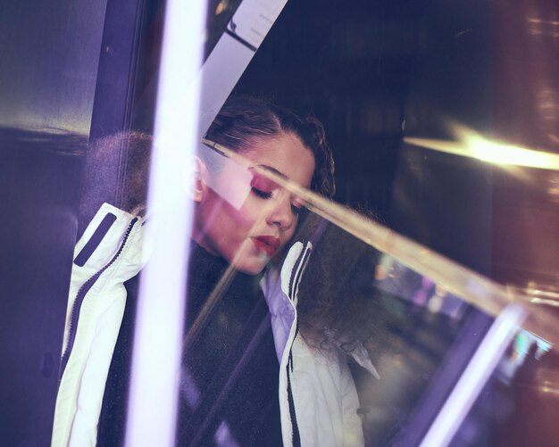 Photo contemplating woman seen through glass