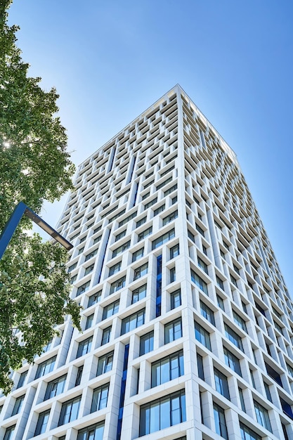 Contemporary high rise urban building with geometric design against cloudless blue sky in sunny day