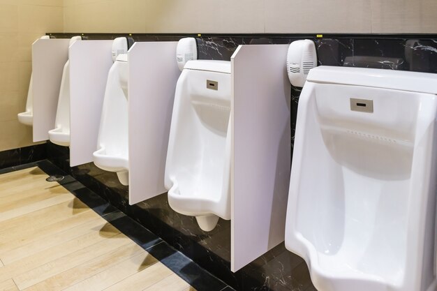 Contemporary interior of white urinals in public toilet