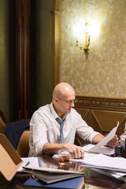 Contemporary mature lawyer looking through juridical paper