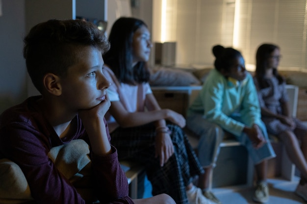 Contemporary schoolchildren watching movie at lesson