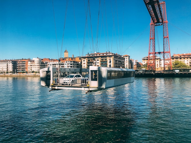 Contemporary transporter bridge over calm river in port city