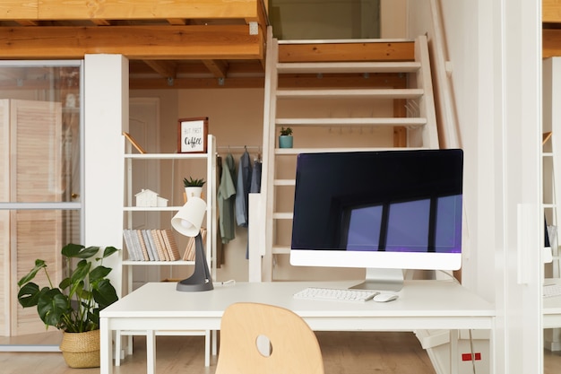 contemporary workplace in two level office apartment with computer desk in foreground