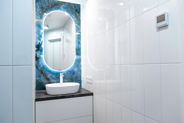 Contemprary bathroom interior with light mirror and sink table