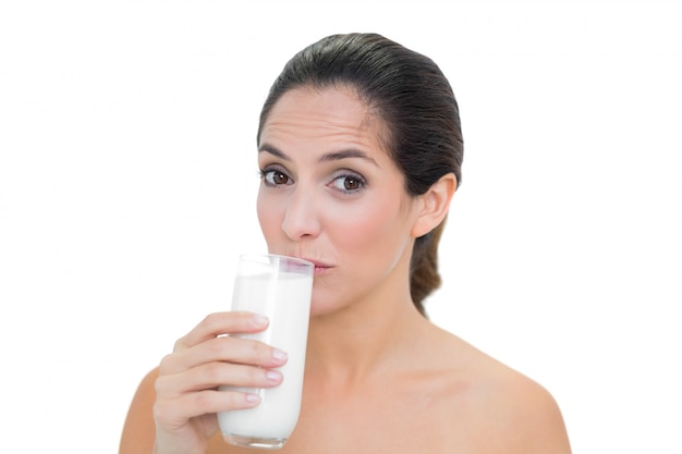 ミルクの内容の裸のブルネットの飲み物のガラス
