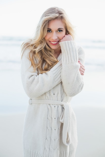 Content blonde woman in wool cardigan looking at camera