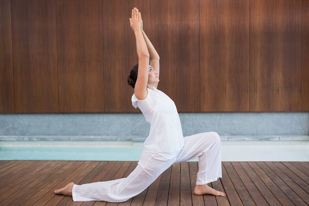 Content brunette in white doing tai chi