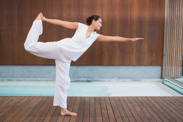 Content brunette in white in the shiva posture