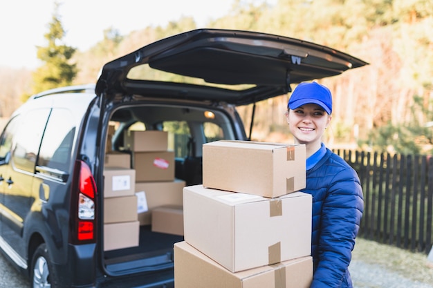 Content courier woman with stack of boxes