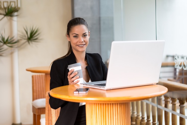 Content executive woman with coffee and laptop