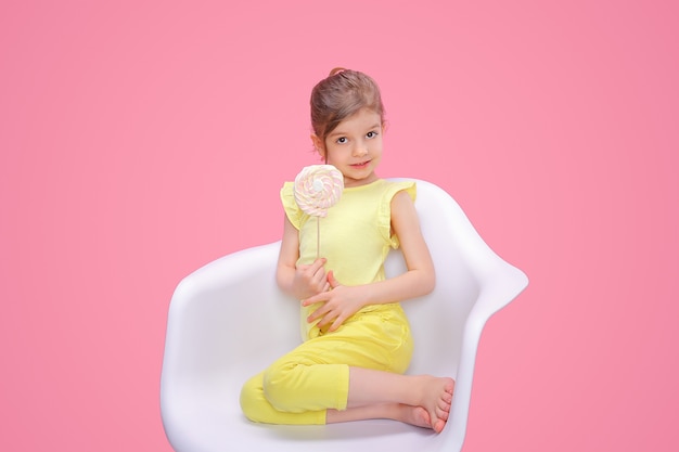 Content girl with candy in chair