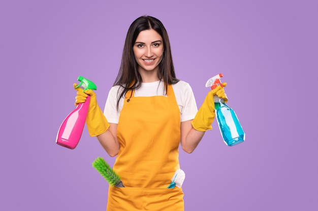 Content maid with detergents looking at camera in studio