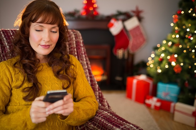 Content redhead using mobile at christmas