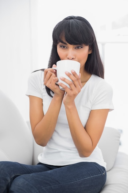 カップのリラックスした女性の飲み物