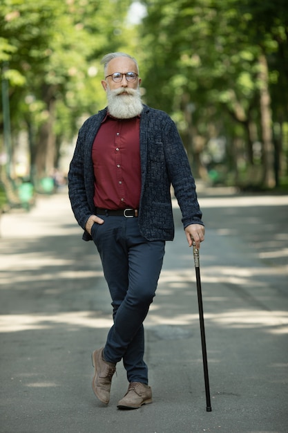 Содержимый старший человек с бородой и носить очки открытый.