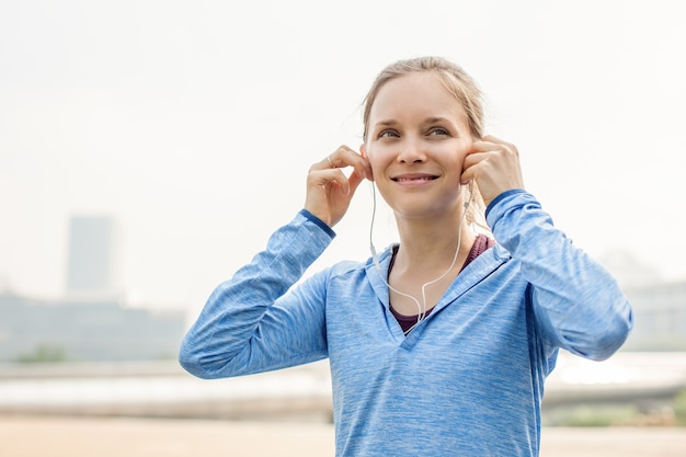 Photo content sporty girl listening to music in city