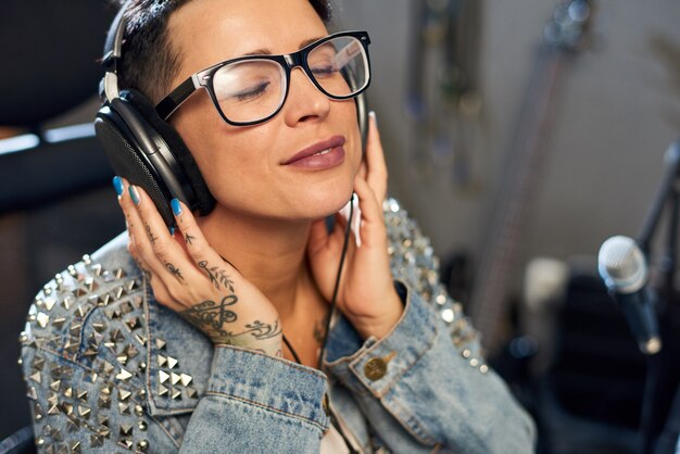 Donna contenta che gode della musica in studio