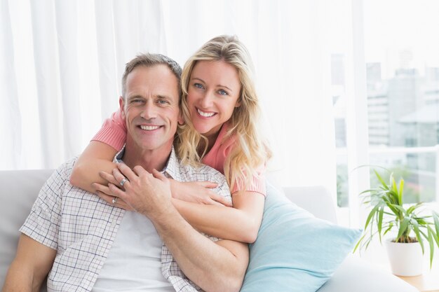 Content woman hugging his husband on the couch