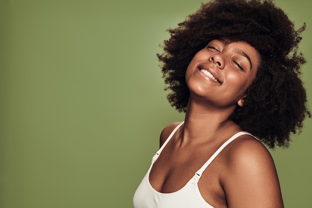 Content young African American female model smiling with closed eyes