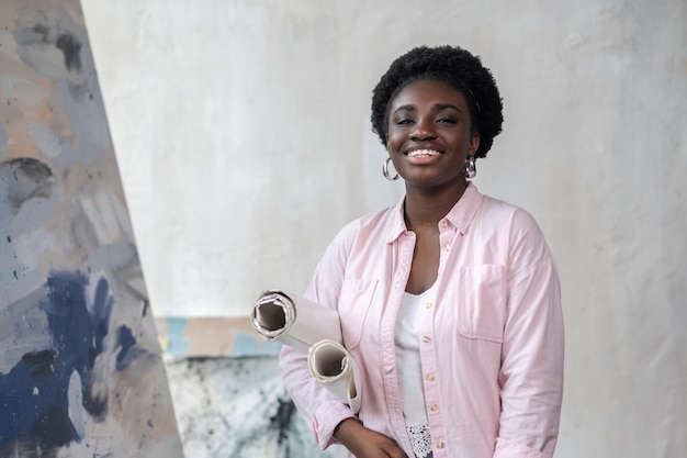 Contented african artist in pink clothes clooking busy in the studio