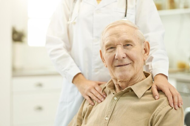 Contented elderly man posing with his medical doctor