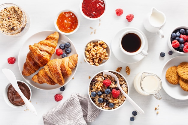 Foto continentaal ontbijt met croissant, jam, chocopasta en koffie. bovenaanzicht