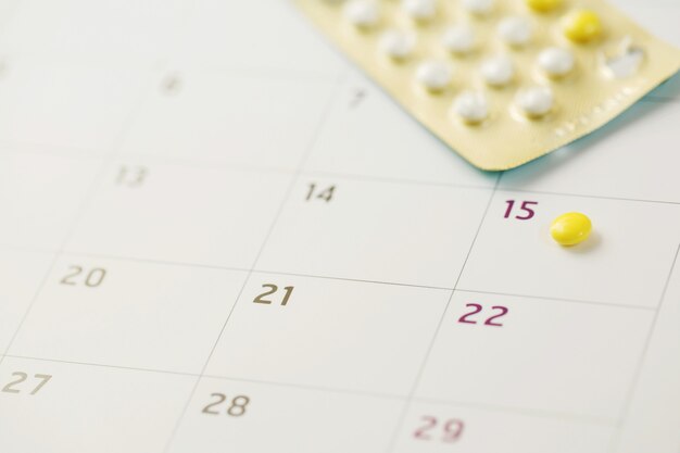 Pillole di controllo contraccettive alla data del calendario. sanità e medicina concetto di controllo delle nascite.