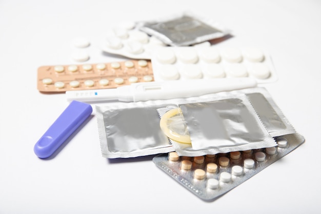 Photo contraceptive pills and condoms on a white background