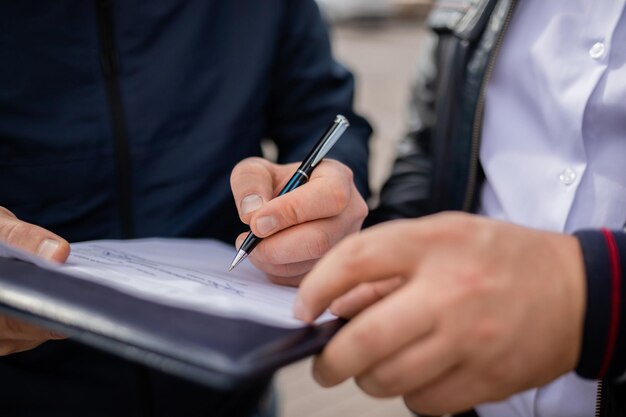 Contract signing close up shot Customer sign papers in dealership office client buying car or purchasing property