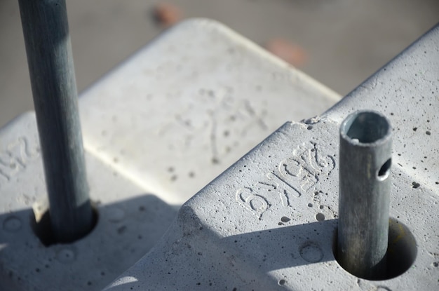 Foto contragewicht of gewichtsbalans betonblokken of bakstenen als onderdeel van hangend staalkabelplatform voor gevelwerken aan hoge gebouwen met meerdere verdiepingen veel blokken met metalen handgrepen