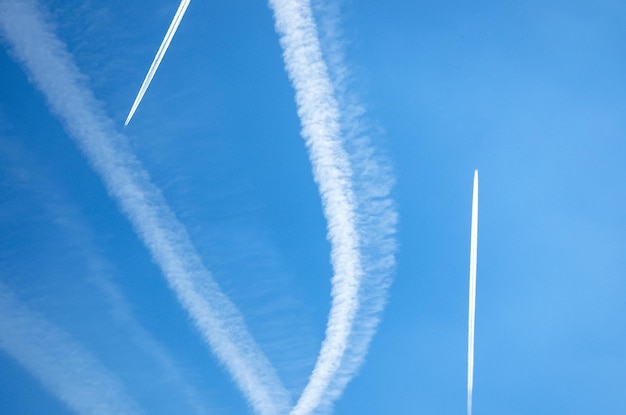 Foto scie di scie di aeroplani in alto nel cielo blu