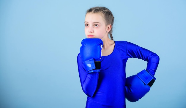 Contrary to stereotype Boxer child in boxing gloves Female boxer change attitudes within sport Rise of women boxers Girl cute boxer on blue background With great power comes great responsibility