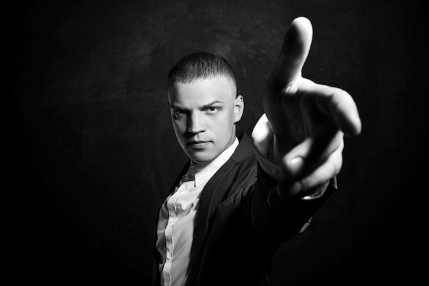 Contrast portrait of a man businessman in an expensive business suit on dark 