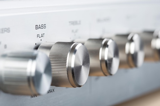 Photo control knobs on a silver metallic vintage amplifier shallow depth of field